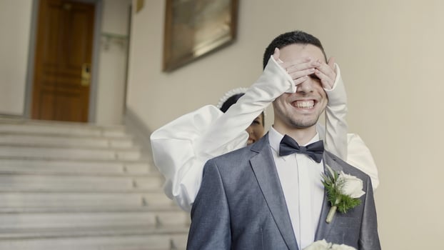 A couple of the bride and groom flirting with each other. Action. Smiling newlyweds filming in a building with bright lighting and decorations. photo