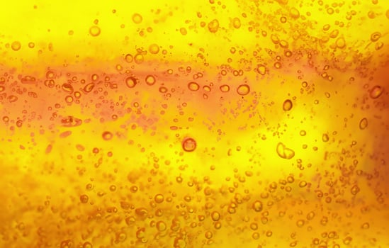 Abstract textured gel background. Yellow and orange liquid with bubbles. photo