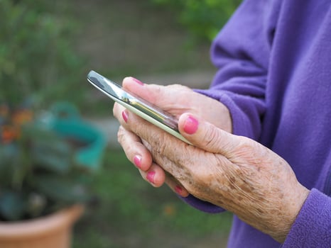 Closeup of elderly woman hands holding mobile phone. photo