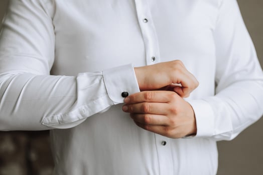 A stylish groom is preparing for the wedding ceremony. Groom's morning. Businessman wearing white shirt, male hands close-up, groom getting ready in the morning before the wedding ceremony photo