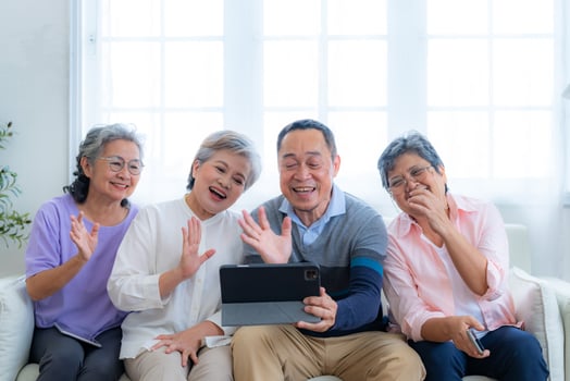 Happiness of the group females and male elderly talking with Call from smart tablet. Senior people are talking and enjoy together at the living room. Joyful retired friends enjoying relaxation. photo
