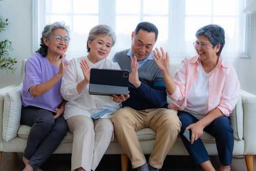 Happiness of the group females and male elderly talking with Call from smart tablet. Senior people are talking and enjoy together at the living room. Joyful retired friends enjoying relaxation. photo