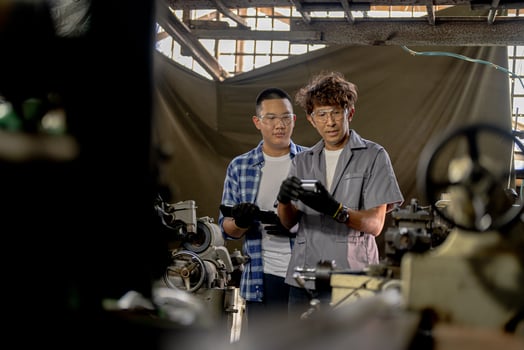 Men are inspecting steel parts for machine installation. team of teacher and student are learning to use heavy machines in steel factory. workers cooperate while doing quality control of manufactured. photo