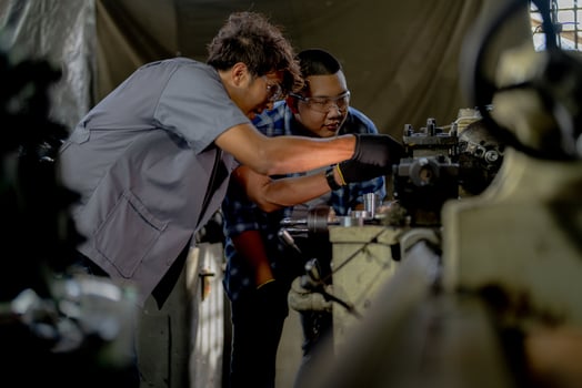 Men are inspecting steel parts for machine installation. team of teacher and student are learning to use heavy machines in steel factory. workers cooperate while doing quality control of manufactured. photo