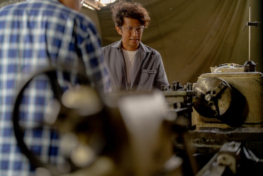 Men are inspecting steel parts for machine installation. team of teacher and student are learning to use heavy machines in steel factory. workers cooperate while doing quality control of manufactured. photo