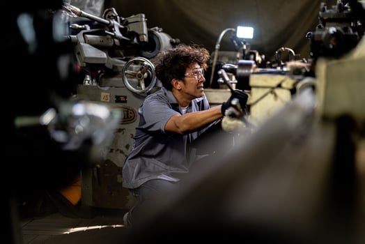 Asian worker in production plant drilling at machine. Professional worker near drilling machine on factory. finishing metal working internal steel surface on lathe grinder machine with flying sparks. photo