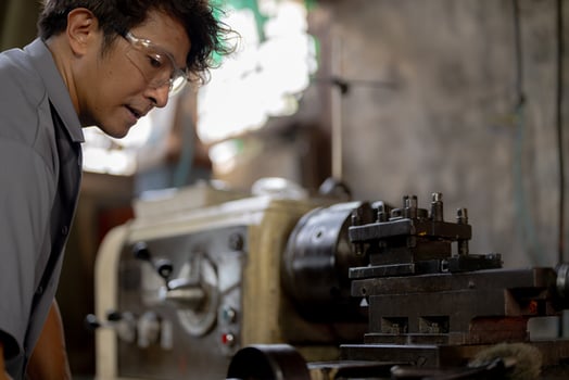 close up operation for Metal Lathes. The steel column rolling in machine. metalworking industry. worker hand checks mechanic engine. Technician repairing drill bit on metal machine in factory photo