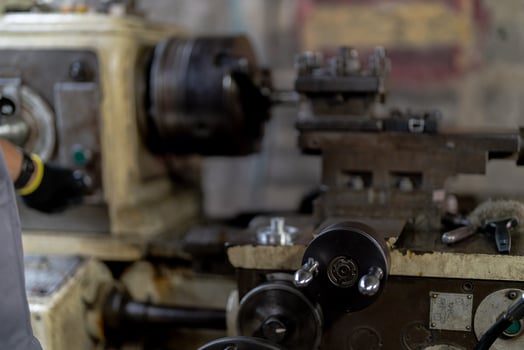 close up hand operation for Metal Lathes. steel column rolling in machine. metalworking industry. worker hand checks mechanic engine. Technician repairing drill bit on metal machine in factory photo