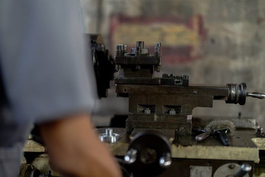 close up hand operation for Metal Lathes. steel column rolling in machine. metalworking industry. worker hand checks mechanic engine. Technician repairing drill bit on metal machine in factory photo
