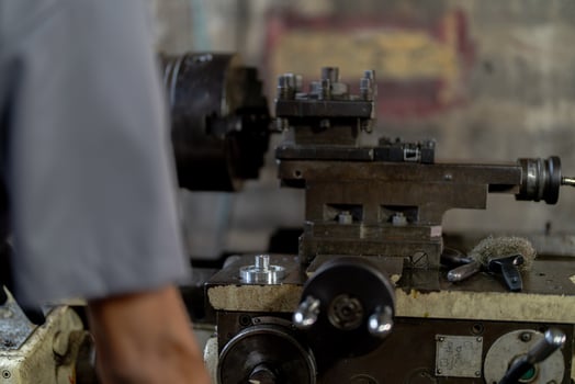 close up hand operation for Metal Lathes. steel column rolling in machine. metalworking industry. worker hand checks mechanic engine. Technician repairing drill bit on metal machine in factory photo