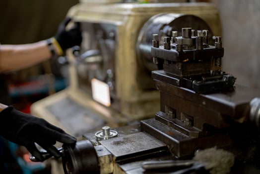 close up hand operation for Metal Lathes. steel column rolling in machine. metalworking industry. worker hand checks mechanic engine. Technician repairing drill bit on metal machine in factory photo