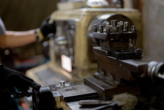 close up hand operation for Metal Lathes. steel column rolling in machine. metalworking industry. worker hand checks mechanic engine. Technician repairing drill bit on metal machine in factory photo