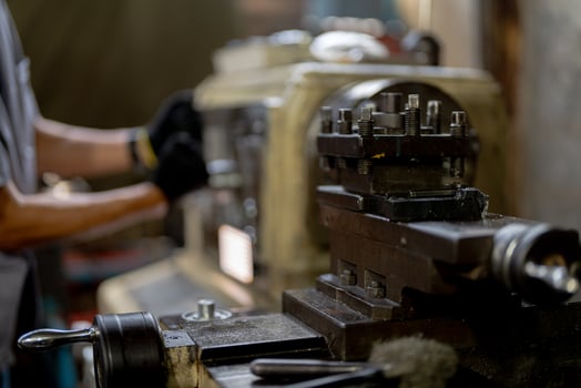close up hand operation for Metal Lathes. steel column rolling in machine. metalworking industry. worker hand checks mechanic engine. Technician repairing drill bit on metal machine in factory photo