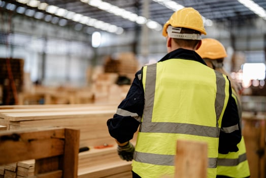 Workers evaluate timber wood in a warehouse for suitability in manufacturing processes. photo