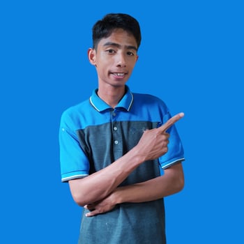 excited asian man wearing white t-shirt pointing to the copy space on the side, isolated white background. photo