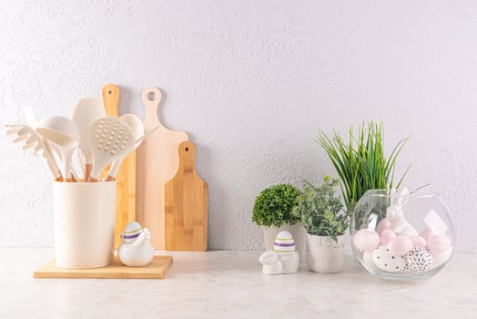 Easter holiday decorations on a light kitchen countertop with eco-friendly kitchen utensils and green plants in pots. Easter concept. photo