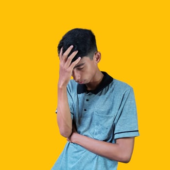 confused asian young man yellow t-shirt, isolated white background photo