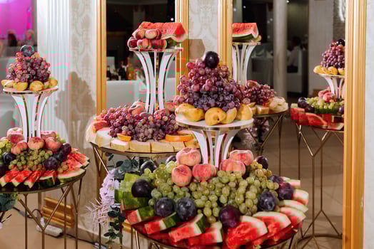 Wedding decorations. Reception. Buffet. Fruits and cheese on plates with bread in boxes. Food bar decorated by flowers and lanters photo