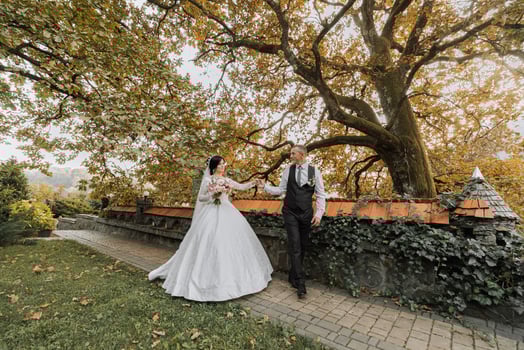 Full body portrait of a young bride and groom enjoying a romantic moment outside at sunset on a beautiful autumn day. Wedding couple. Standing face to face photo