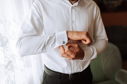 Close-up of a man and a button-down shirt. clothing for interviews, work and corporate fashion for business. The hands of a male person, the groom is preparing for the wedding photo