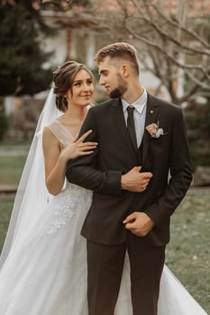 Romantic portrait of a stylish bride and groom in a wedding dress, in the garden photo