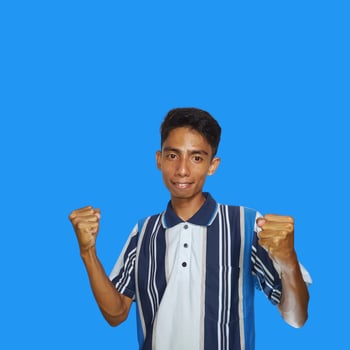 The enthusiastic face of the Asian youth clenched his fists. isolated on blue background. photo