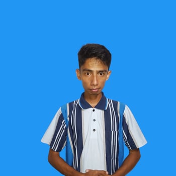 serious young asian man wearing colorful t-shirt, isolated blue background. photo