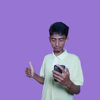 Asian man smiling face with okay gesture while holding smart phone, isolated on purple background photo