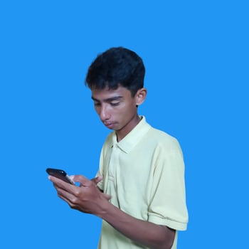 Young asian man surprised looking at smart phone, wearing yellow t-shirt, isolated blue background. photo