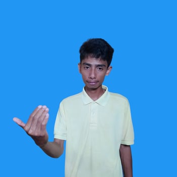 Young Asian man isolated on blue background. inviting come by hand. blue background photo