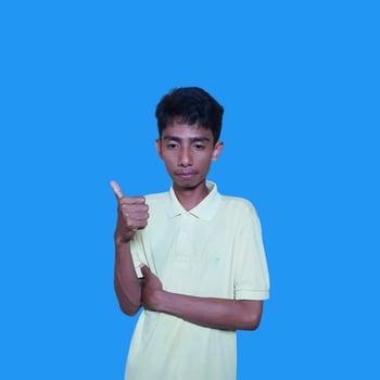 excited asian man wearing yellow t-shirt pointing to the copy space on the side blue background. photo