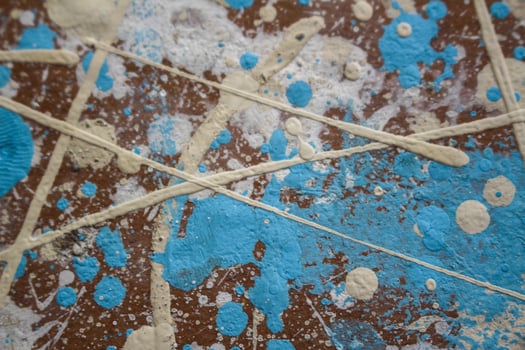 Abstract spots, drops of yellow blue white paint on a brown wooden surface photo