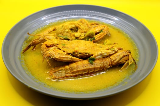 spicy crab in curry sauce on yellow background, Thai food. photo