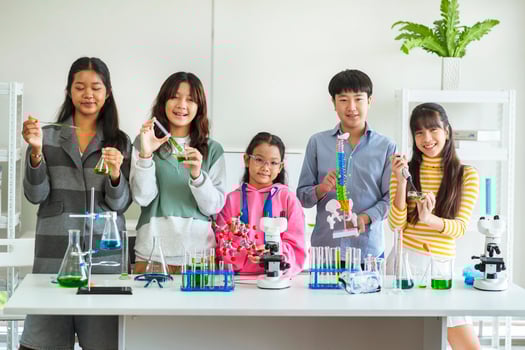 Group of children doing chemistry experiments for classroom learning photo