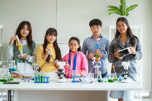 Group of children doing chemistry experiments for classroom learning photo