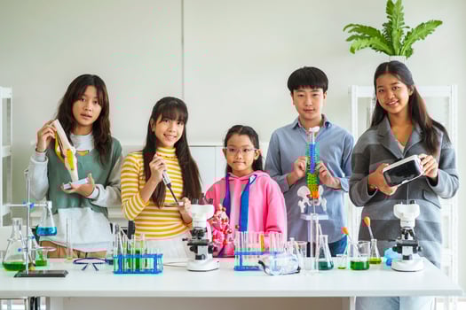 Group of children doing chemistry experiments for classroom learning photo