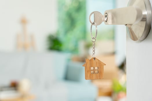 Moving house, relocation. The key was inserted into the door of the new house, inside the room was a cardboard box containing personal belongings and furniture. move in the apartment or condominium photo