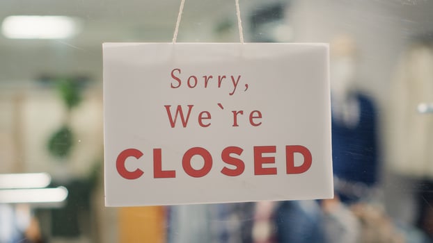 Extreme close up shot of message on designer clothing men premium showroom door announcing customers that shop is closed. Sorry we are closed sign in luxury fashion boutique with elegant clothes photo