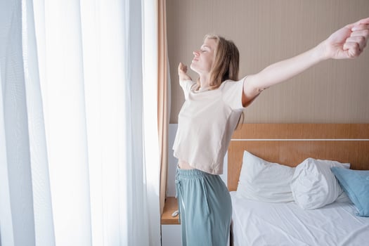 Young woman waking up and stretching in the morning photo