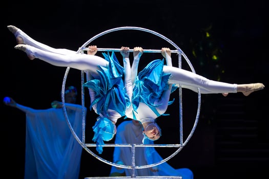Two acrobat girls show a circus number on a dark background. Acrobatic performance. photo