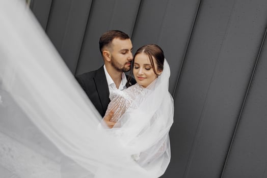 The beautiful bride gently hugs the groom, who hugs her by the shoulders. Wedding concept. The beauty and tenderness of a man and a woman photo