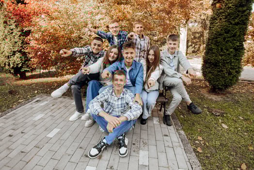 friendship, movement, action, freedom and people concept - group of happy teenagers or school friends posing and having fun outdoors against nature or forest background. photo