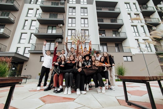 friendship, movement, action, freedom and people concept - group of happy teenagers or school friends posing and having fun outdoors on background of beautiful place or college. photo