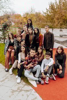 friendship, movement, action, freedom and people concept - group of happy teenagers or school friends posing and having fun outdoors on background of beautiful place or college. photo