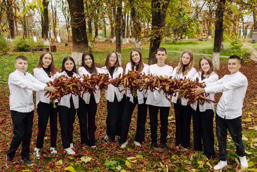 friendship, movement, action, freedom and people concept - group of happy teenagers or school friends posing and having fun outdoors against nature or forest background. photo