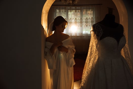 A beautiful brunette bride with a tiara in her hair is getting ready for the wedding in a beautiful robe in boudoir style. Close-up wedding portrait, photo. photo