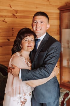 mother helps her adult son prepare for the wedding ceremony. An emotional and touching moment at a wedding. A mother hugs her son photo