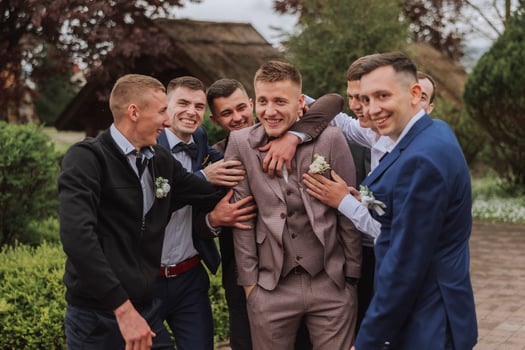 Cheerful, young, energetic witnesses of the groom next to the groom. Friends congratulate the groom. Groom and his funny friends having fun on the wedding day of the newlyweds. photo
