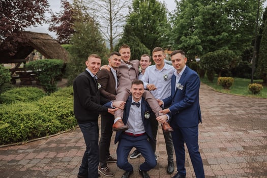 Cheerful, young, energetic witnesses of the groom next to the groom. Friends congratulate the groom. Groom and his funny friends having fun on the wedding day of the newlyweds. photo