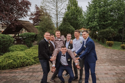 Cheerful, young, energetic witnesses of the groom next to the groom. Friends congratulate the groom. Groom and his funny friends having fun on the wedding day of the newlyweds. photo